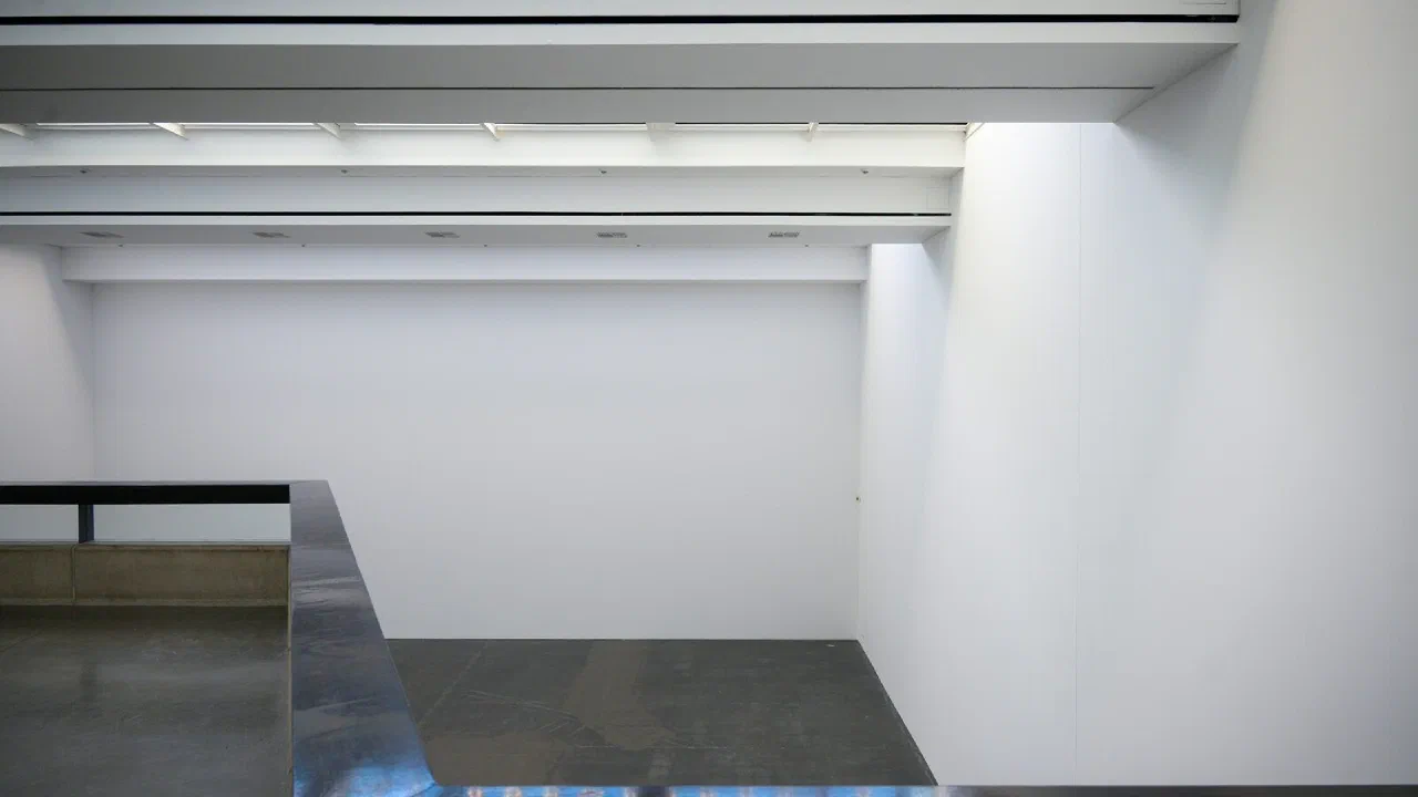 An empty entrance hall with white walls and a polished reflective floor